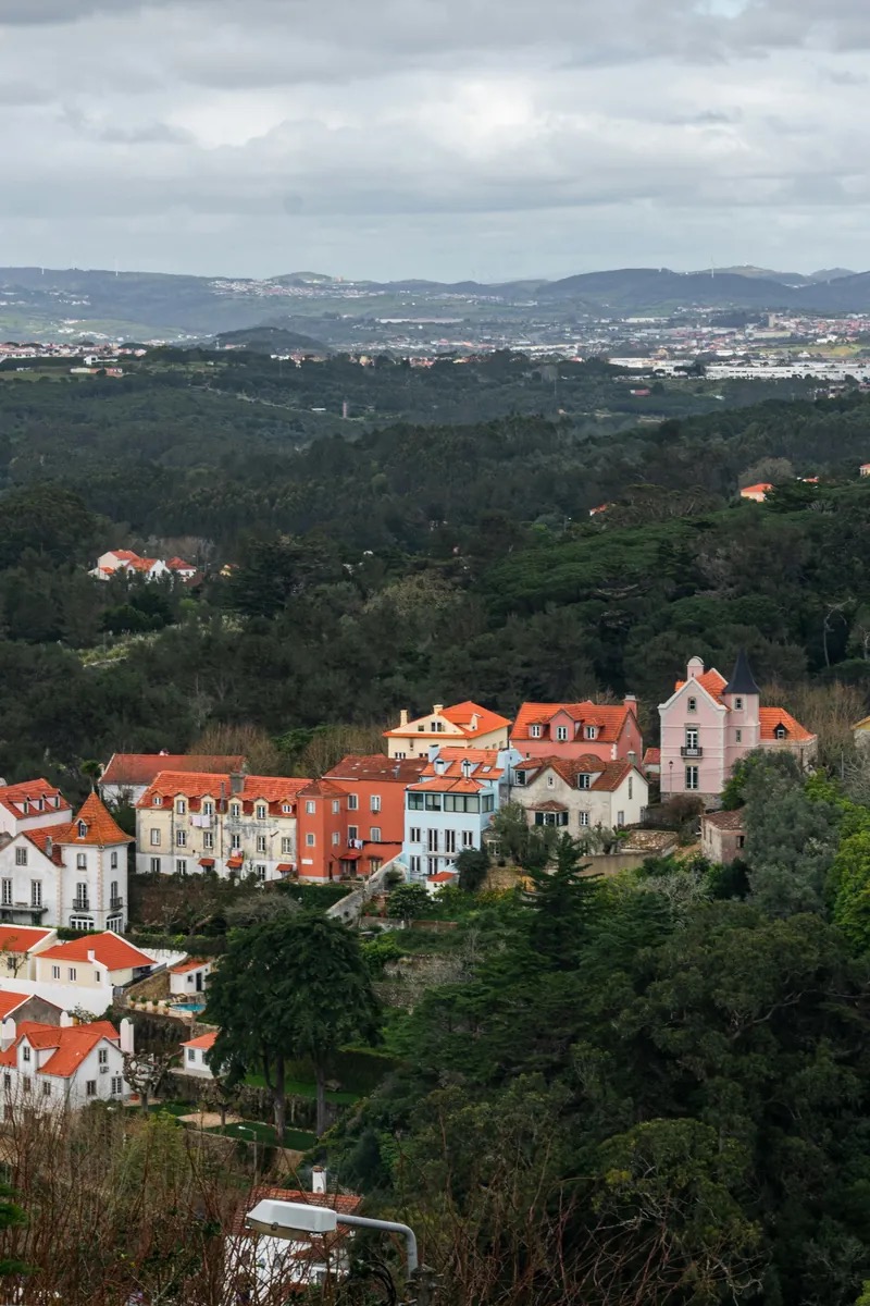 Moss-covered stone and cork-lined doorways of the Convento dos Capuchos among granite boulders and dense woodland in the Serra de Sintra, Portugal